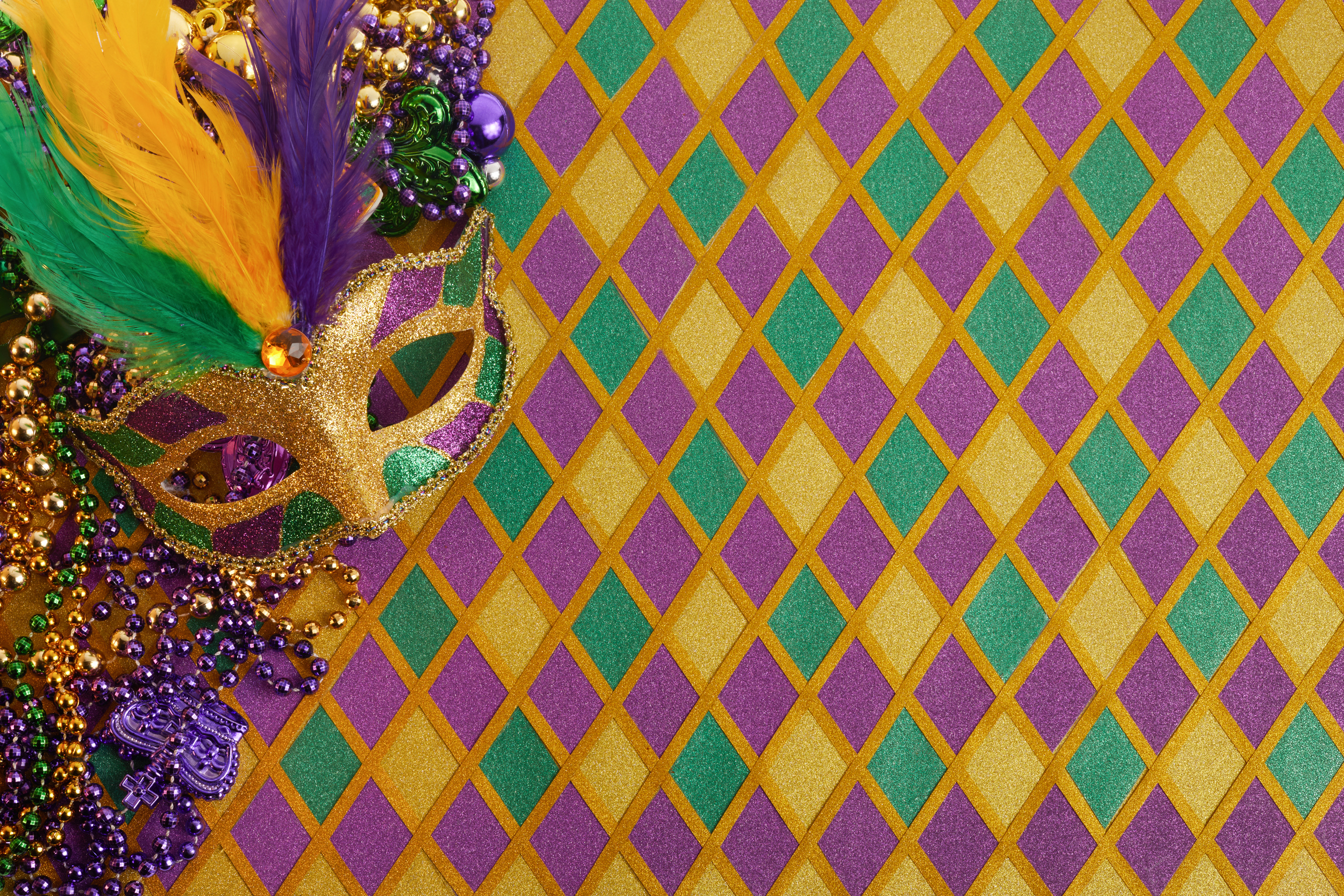 Frame of Mardi Gras Mask and Colorful Mardi Gras Beads on Diamond Shaped Background